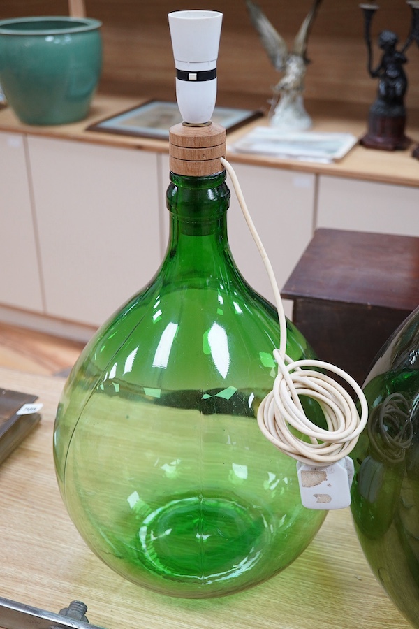 Two green glass carboys, one converted to a lamp, 58cm high overall. Condition - good, untested